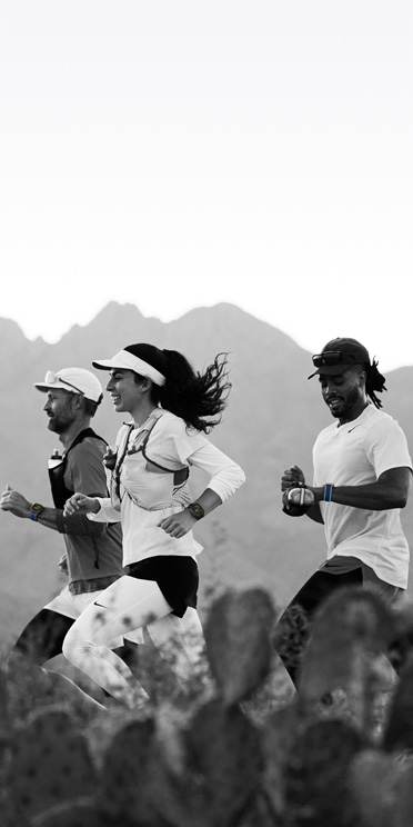 Трима души бягат по пустинна пътека и проследяват тренировката си с Apple Watch Ultra 3