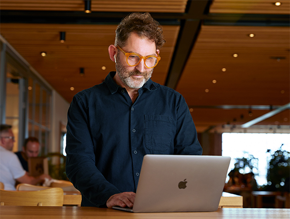 Una persona del equipo Corporativo de Apple usando una MacBook en un Caffè Macs.