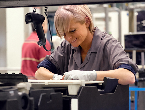 En una fábrica de Apple, dos empleados examinan las carcasas de aluminio de la MacBook en racks anodizados de titanio.