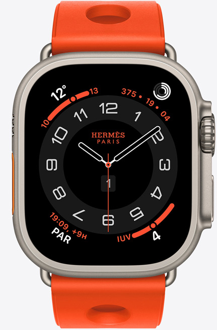 Apple Watch Hermès Ultra 3, esfera analógica Circulaire, (aguja horaria, minutero y segundero, complicaciones: Tiempo, anillos de Actividad, hora de París e Índice UV), caja de titanio, color natural, lateral derecho, Digital Crown, botón lateral elevado, con la correa Scub'H Diving, color Orange Néon (naranja brillante), fabricada en goma moldeada, aberturas circulares en el centro