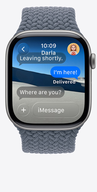 Apple Watch Series 11 med urkasse i space grey aluminium, Liveoversættelse ændrer sproget i iMessage til engelsk og Flettet Solo Loop i stålblå