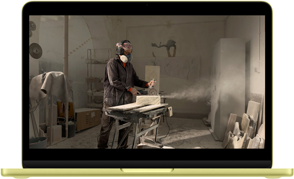 MacBook Neo, citrusna boja, na ekranu se prikazuje QuickTime video