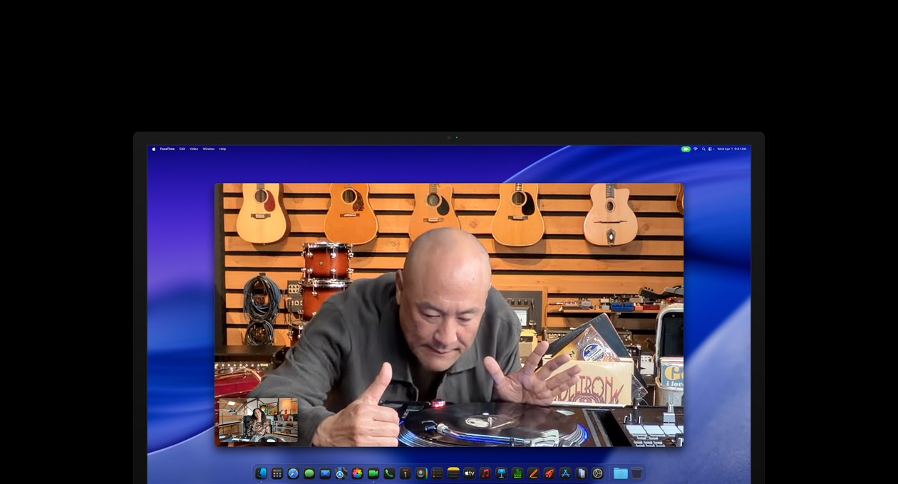 Selama panggilan video, seseorang di toko musik memperhatikan alat pemutar vinyl dengan cermat. Ia tetap berada di tengah frame berkat kamera Center Stage