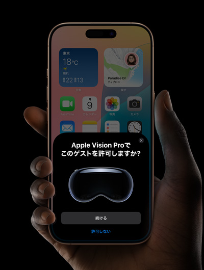 iPhoneを持つ手。iPhoneの画面上に表示されているウィンドウには、「Apple Vision Proでこのゲストを許可しますか？」というメッセージと、「続ける」および「拒否」と書かれたボタンが表示されている