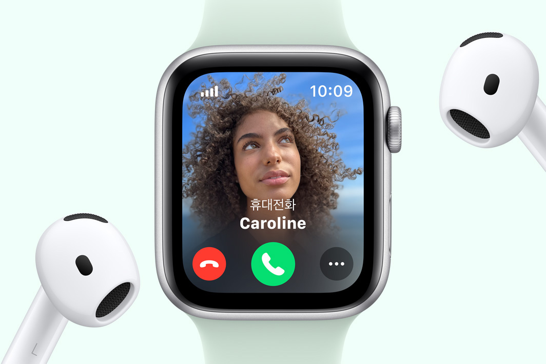 전화가 걸려 오는 Apple Watch SE와 그 옆에 한 쌍의 AirPods이 있는 모습