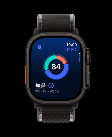 화면에 수면 점수 원형 그래프가 표시된 블랙 색상 티타늄 케이스의 Apple Watch Ultra 3, 그리고 블랙/차콜 색상 트레일 루프