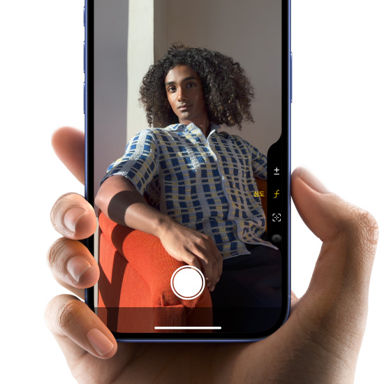 울트라마린 색상의 iPhone 16을 손으로 든 채 카메라 컨트롤 버튼에 엄지를 대고 문지르듯 움직여 피사계 심도를 조절하는 모습