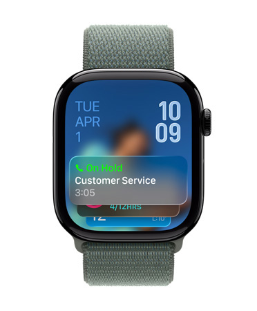 세이지 밴드를 장착한 제트 블랙 마감의 Apple Watch, 페이스 하단에는 통화 대기 지원 알림, 왼쪽 상단에 날짜, 오른쪽 상단에는 숫자가 세로로 쌓인 형태로 시간이 표시된 모습