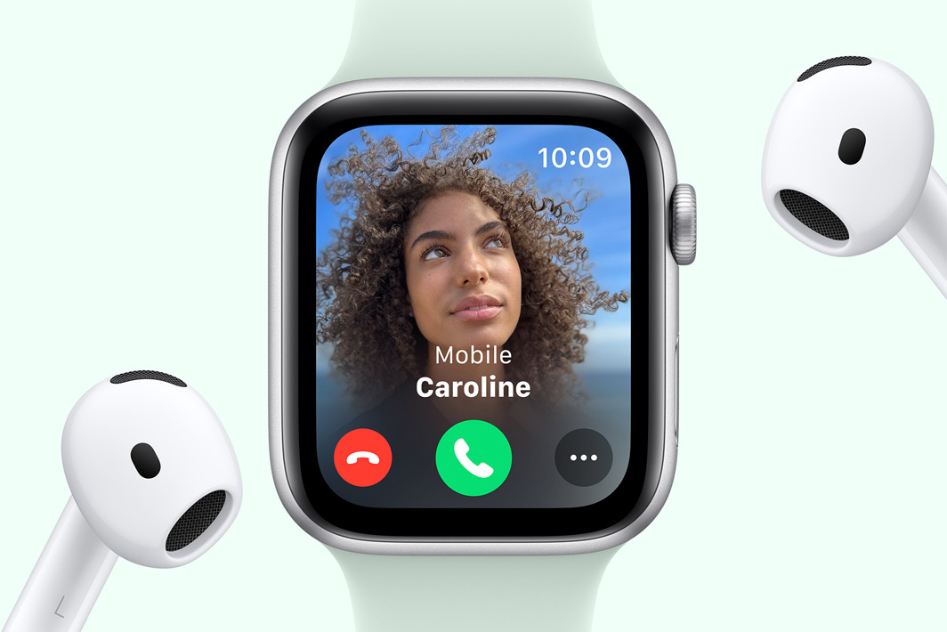 Apple Watch SE affichant un appel entrant, à côté d’une paire d’AirPods