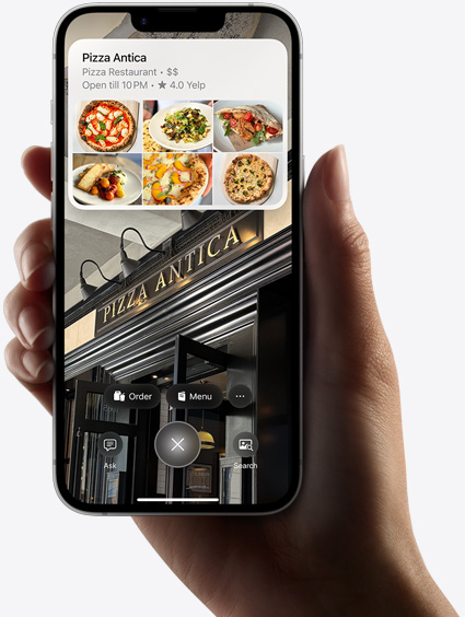 يد شخص تحمل جهاز iPhone 16e وهو يعرض نتائج بحث باستخدام الذكاء المرئي.