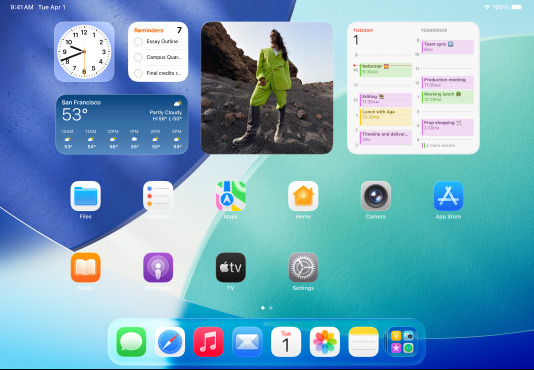 三款型號的 iPad 橫向放置,放在中間的一部位於另外兩部 iPad 的前方。Apple Pencil 以磁力貼合在中間那部 iPad 的頂部,其主畫面展示 Liquid Glass 效果的彩色 app 圖像。位於左邊的 iPad 螢幕正展示預覽程式 app,而右邊的螢幕則展示主畫面,多個檔案從 Dock 上以扇形垂直展開