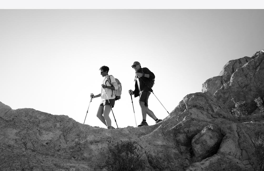 Dos personas con un Apple Watch Ultra 3 hacen senderismo en la montaña