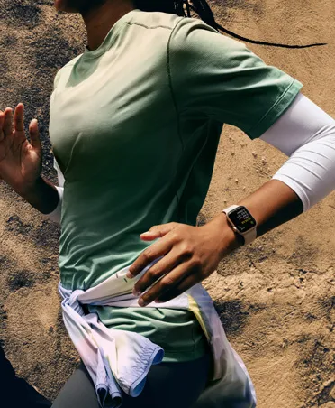 Workout Buddy 傳訊息給跑者，跑者配戴 Apple Watch SE 3 以追蹤體能訓練