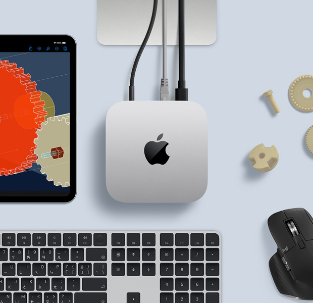 擺放在桌面的銀色 Mac mini 俯視圖,旁邊放著黑色配銀色的無線鍵盤、黑色無線滑鼠和一部 iPad