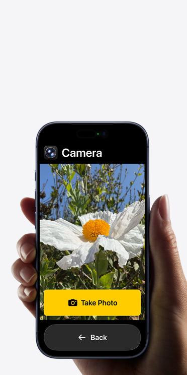 iPhone 17 Pro screen showing simplified Camera app interface with a white flower in the frame, “Take Photo” button, and “Back button below