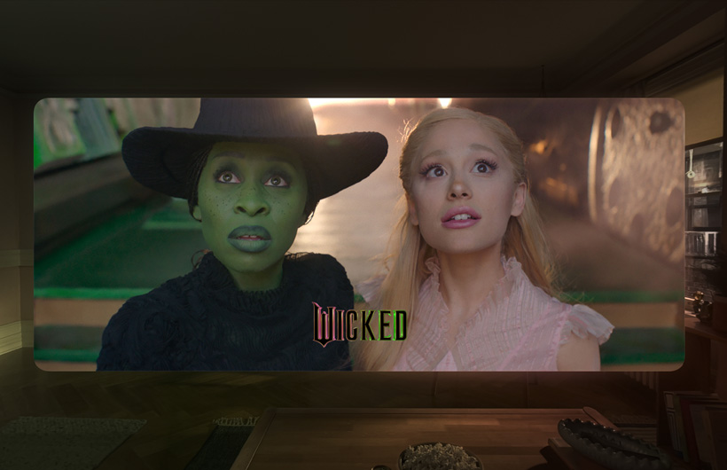 Les deux personnages principaux du film Wicked sont affichés dans l’app Apple TV sur Apple Vision Pro.