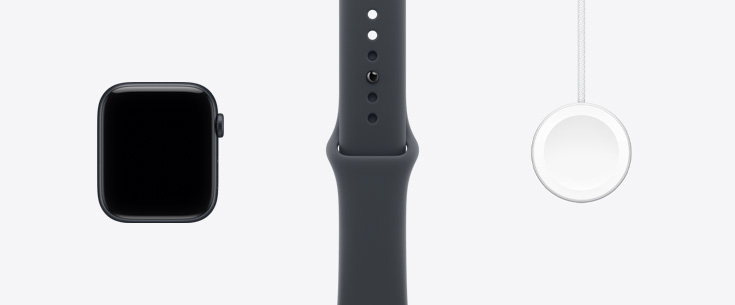 Apple Watch SE 3 午夜色鋁金屬錶殼的機身正面，展示延伸至邊緣的顯示器；一旁是午夜色運動型錶帶，以及 Apple Watch 磁性快速充電器對 USB-C 連接線