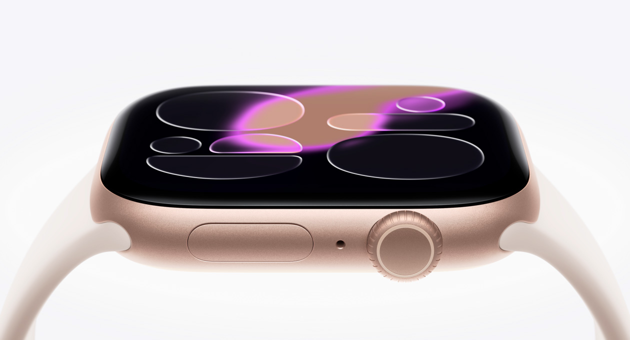 Apple Watch Series 11，展示玫瑰金色鋁金屬錶殼，搭配淡胭粉色運動型錶帶，螢幕顯示流動錶面，機身右側展示數位錶冠、麥克風、側邊按鈕