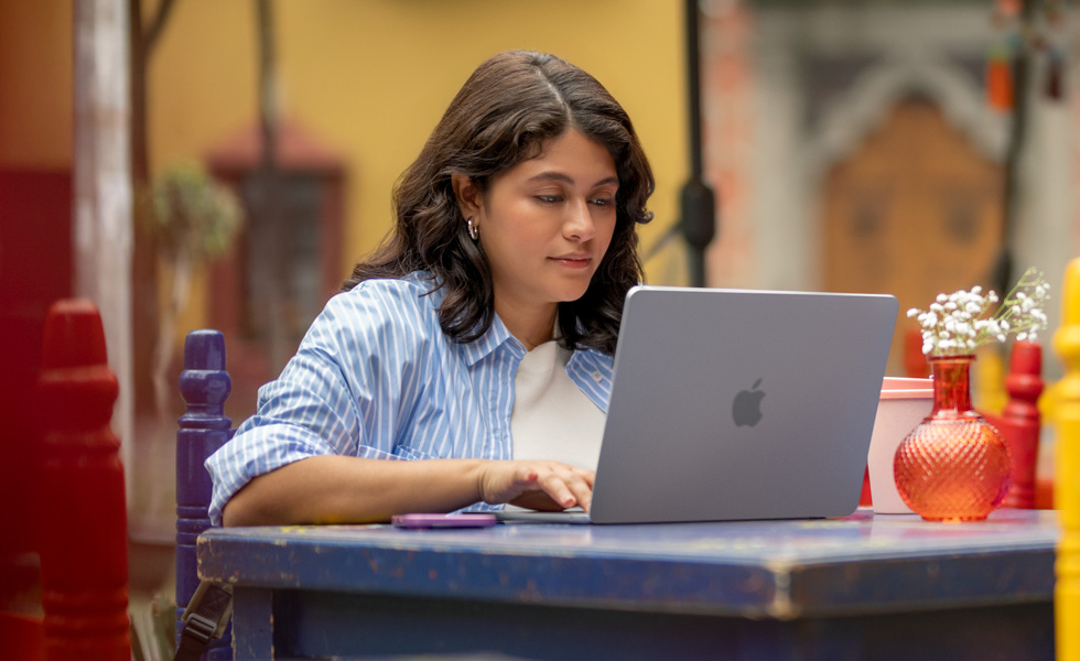 Una studentessa che scrive sul suo MacBook