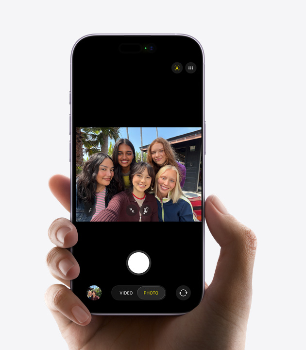 iPhone front exterior, capturing selfie video of three people with Center Stage front camera, yellow squares outlining faces to show automatic framing