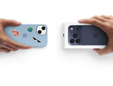 Dos manos intercambian un iPhone 13 con funda de silicona y pegatinas en la parte trasera por un nuevo iPhone 17 en su caja.