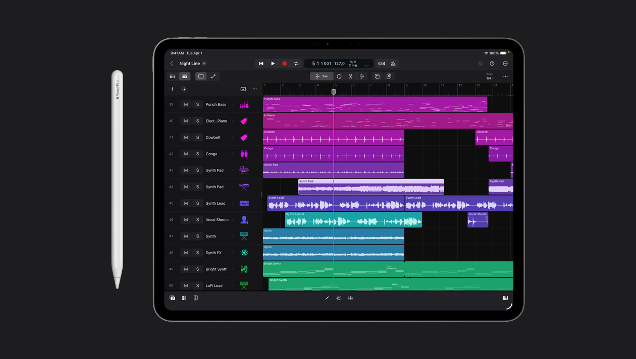 Écran d’un iPad Pro 13 pouces montrant l’espace de travail Logic Pro, liste de différents instruments dans le panneau de gauche et ondes sonores correspondantes en différentes couleurs à droite, un Apple Pencil posé à gauche de l’appareil