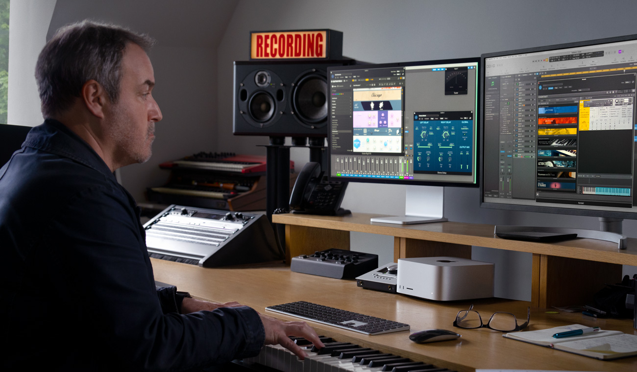 Osoba używająca pianina do komponowania miksów audio z wykorzystaniem Maca Studio i Studio Display