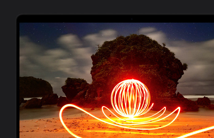 Pantalla de un MacBook Pro que muestra una instalación artística muy luminosa en una playa, lo que ilustra el contraste de la pantalla gracias al rango dinámico extremo