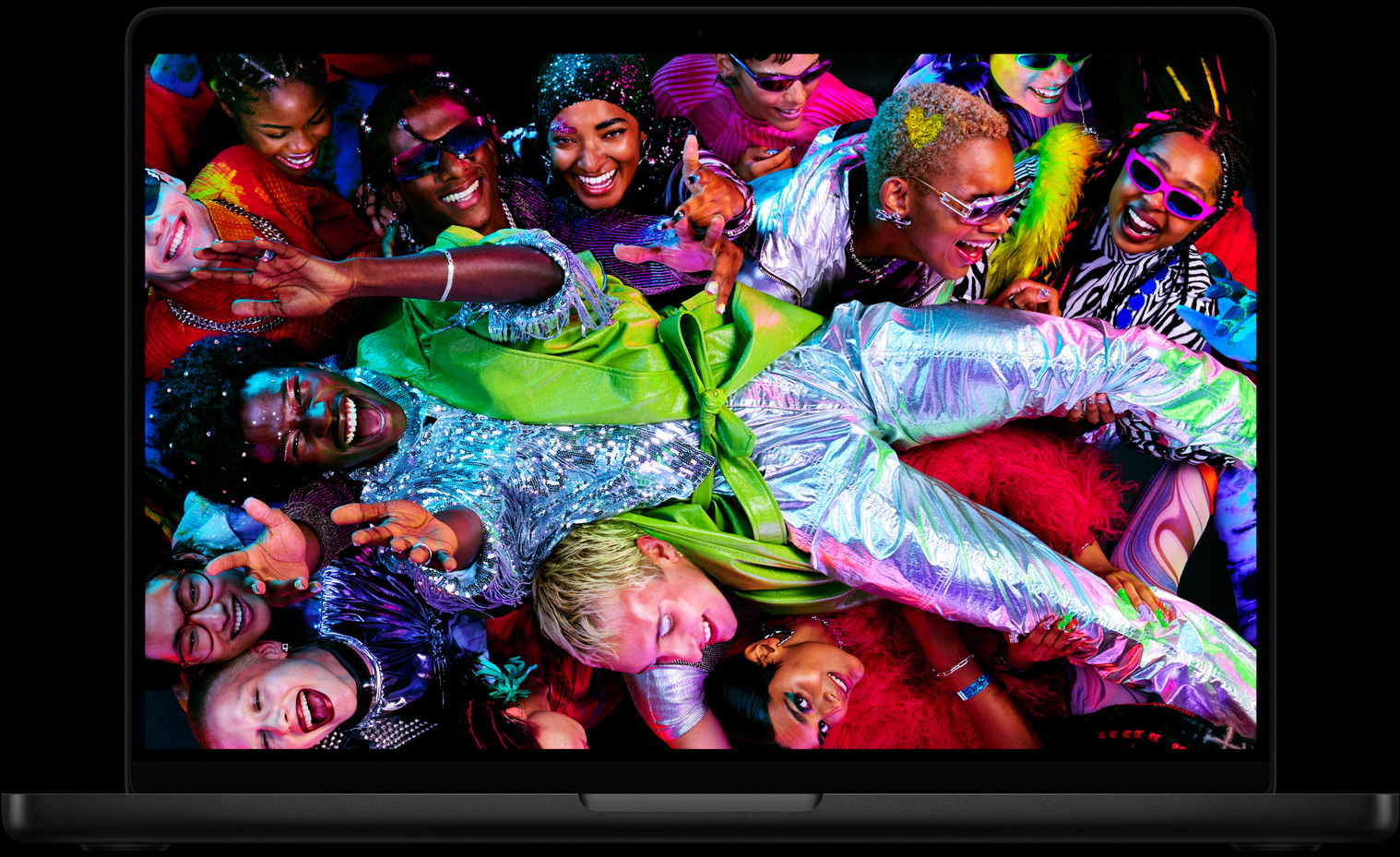 MacBook Pro con la pantalla a todo color que muestra a una persona llevada en volandas en una fiesta, destaca la nitidez de la pantalla Liquid Retina XDR