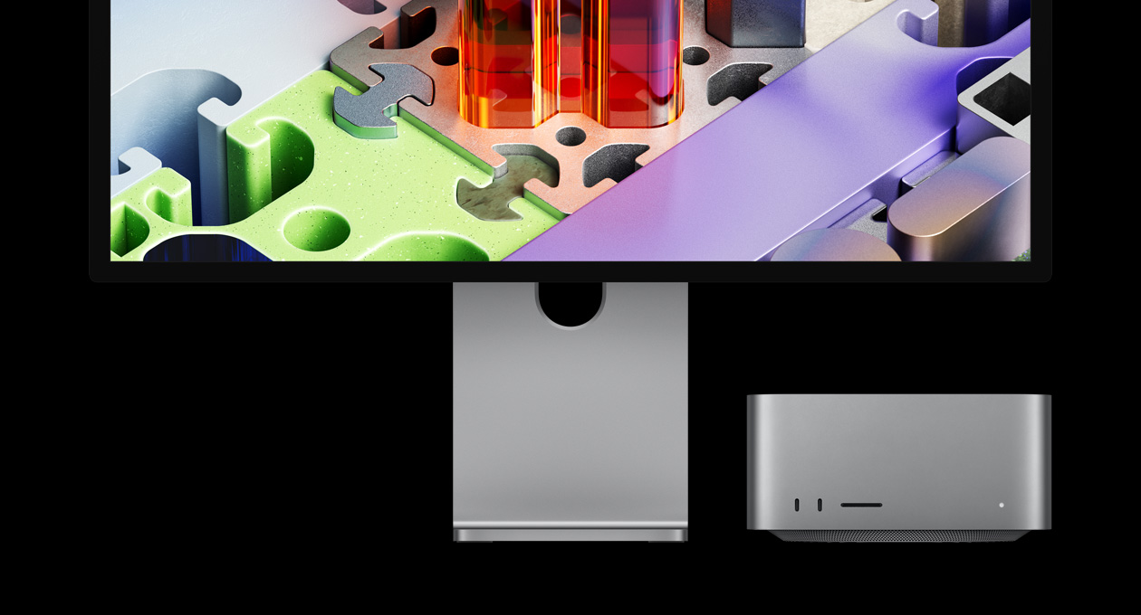 Un Mac Studio jumelé à un Studio Display XDR, l’appareil est glissé sous le moniteur : le Studio Display XDR affiche un fond d’écran tridimensionnel évoquant un puzzle
